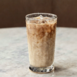 Nescafe Eiskaffee im Glas mit Eis und Milch